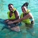 Guests petting a nurse shark while standing in chest deep water